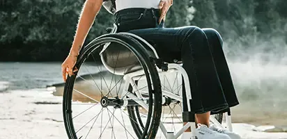 A person in a wheelchair outside in a park