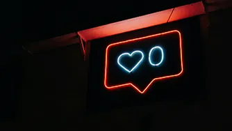 Neon light of a social media like count at zero.